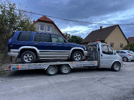 Kék terepjáró szállítása ezüst autómentőn
